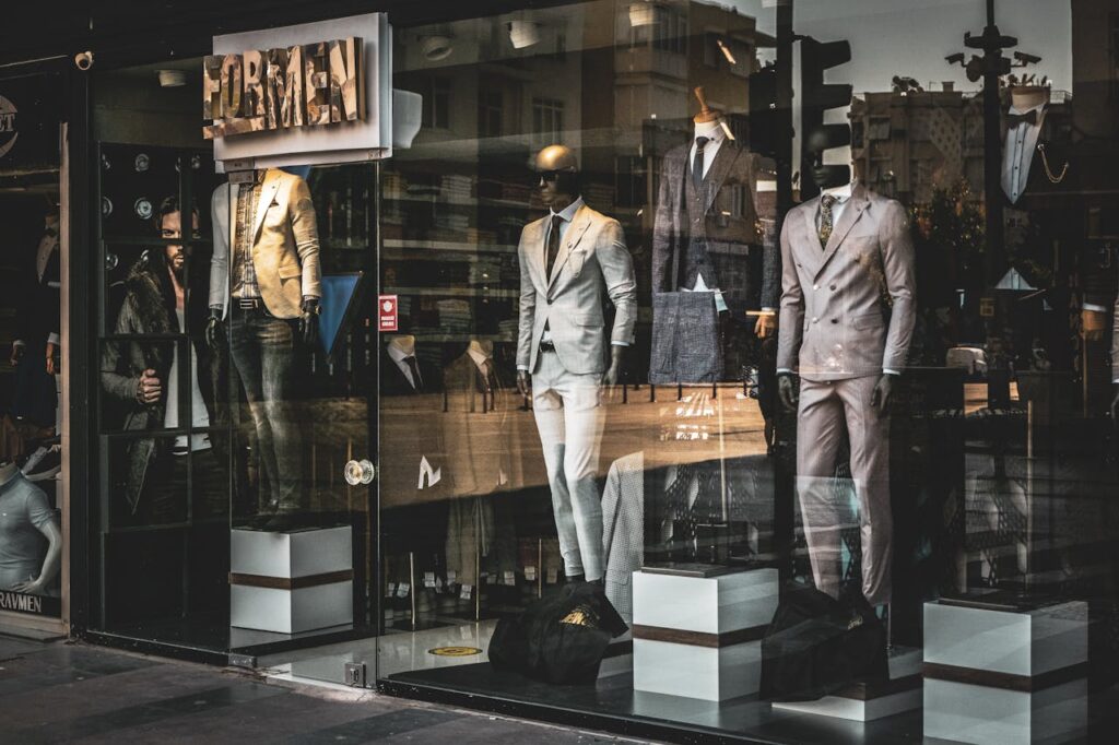 Stylish men's suits on mannequins in a boutique window display. Perfect for fashion and retail themes.